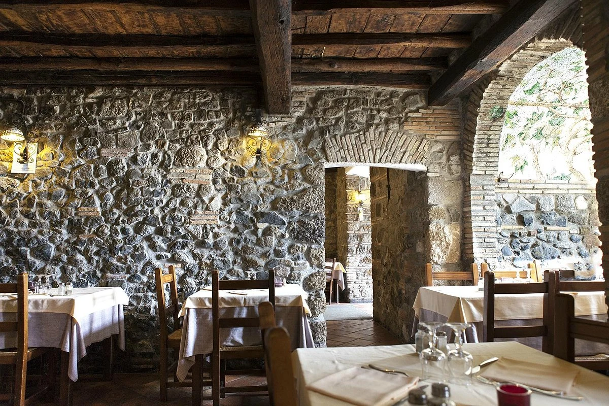 Le sale in pietra e i tavoli apparecchiati della Tavernetta